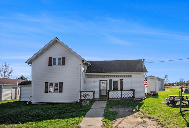 view of property featuring a front lawn, an outbuilding, and a garage