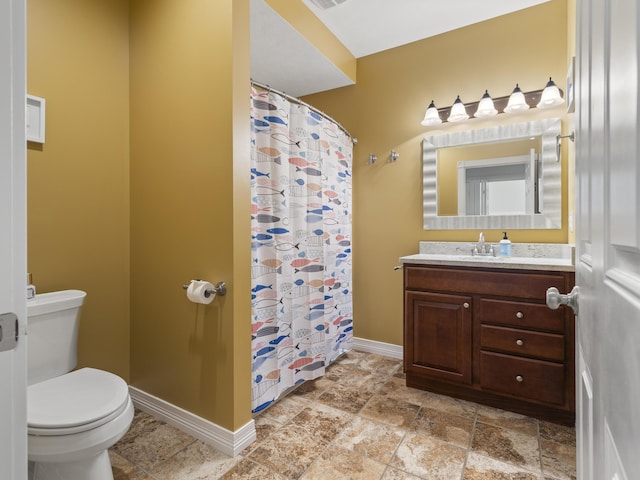 87 S Center St, Beulah, MI 49617 - bathroom featuring toilet, baseboards, vanity, a shower with curtain, and stone finish floors