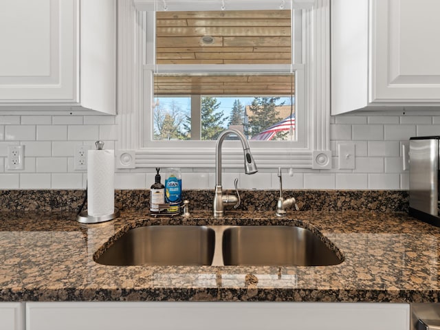 87 S Center St, Beulah, MI 49617 - kitchen view of a sink, white cabinetry, and backsplash