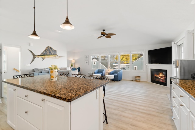 87 S Center St, Beulah, MI 49617 - kitchen with open floor plan, ceiling fan, a kitchen island, light wood-style floors, and a kitchen breakfast bar