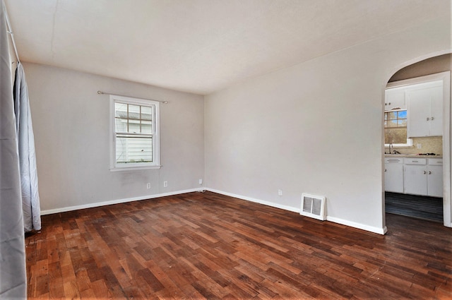 spare room with sink and dark wood-type flooring