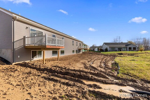 rear view of property featuring a wooden deck