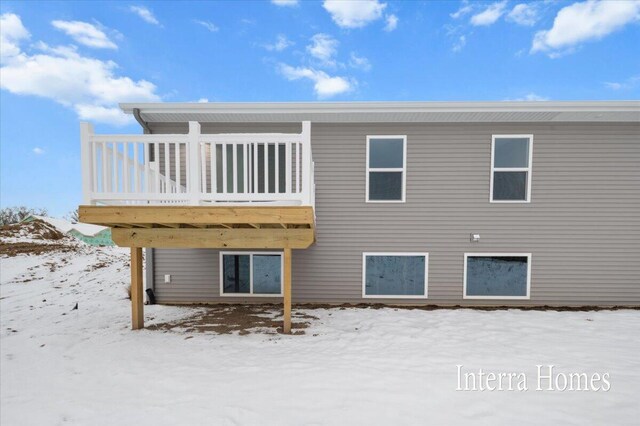 snow covered rear of property featuring a wooden deck