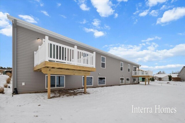 snow covered rear of property featuring a deck