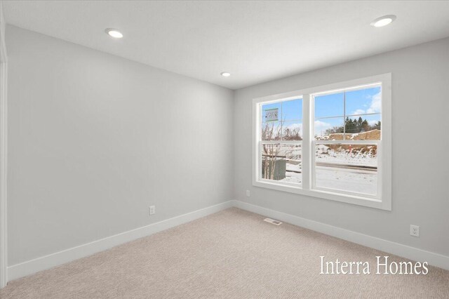 empty room featuring light carpet, visible vents, recessed lighting, and baseboards