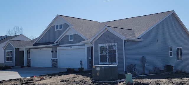 view of front of house featuring roof with shingles, central AC, and concrete driveway