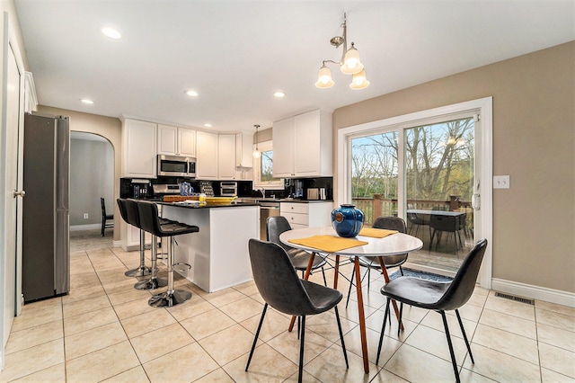 kitchen featuring white cabinetry, light tile patterned floors, appliances with stainless steel finishes, and tasteful backsplash