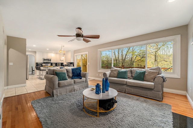 living room featuring light wood-type flooring and ceiling fan