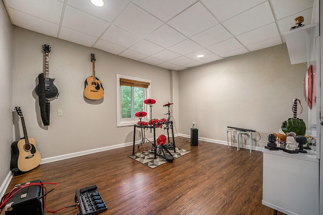 exercise area featuring a drop ceiling and dark hardwood / wood-style floors