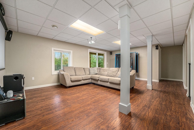 living room with a paneled ceiling and dark hardwood / wood-style floors