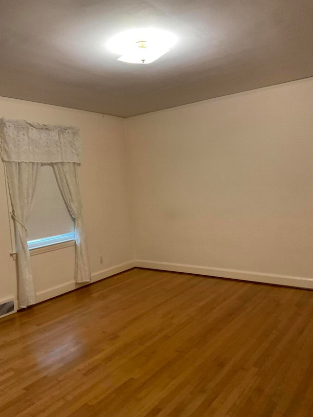 spare room featuring wood-type flooring