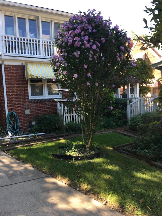 view of home's exterior with a lawn and a balcony