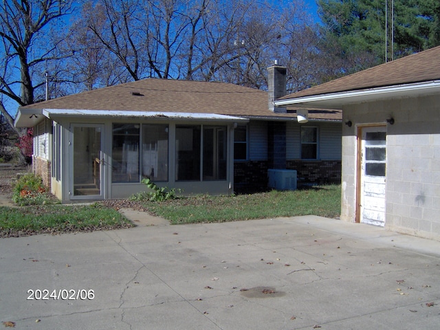 rear view of property with a sunroom, cooling unit, and a patio