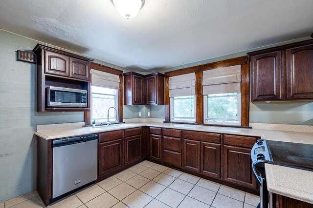 1820 River Bluff Rd, Niles, MI 49120 - kitchen with stainless steel appliances, a sink, light countertops, and light tile patterned floors