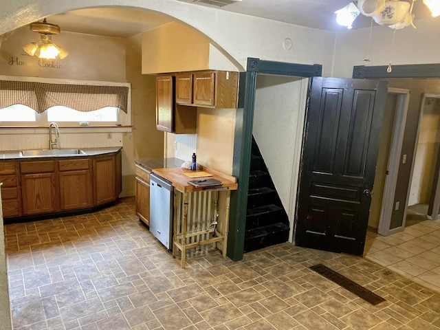 kitchen with vaulted ceiling, sink, stainless steel dishwasher, ceiling fan, and wood counters