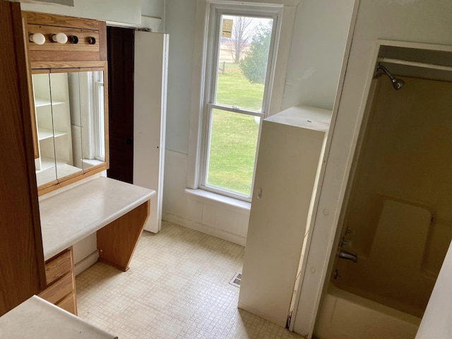 bathroom with tile patterned floors, plenty of natural light, and tub / shower combination