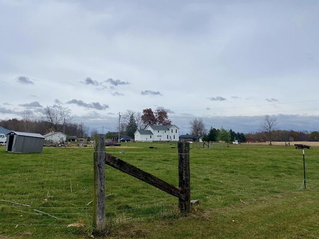 view of yard with a rural view and an outbuilding