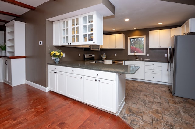 kitchen with white cabinets, kitchen peninsula, and appliances with stainless steel finishes