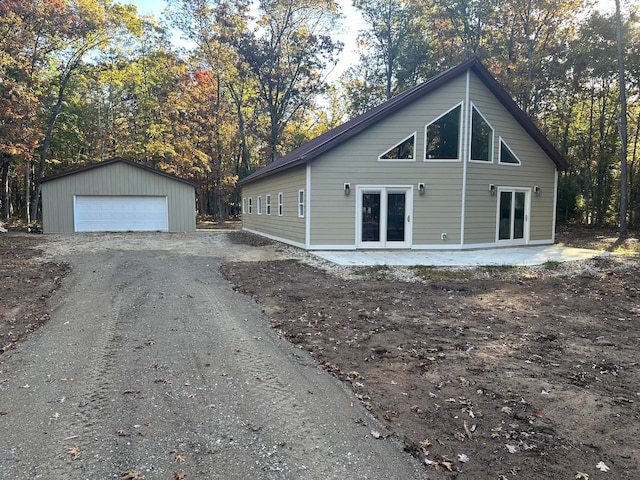 view of side of home featuring an outbuilding, a garage, and french doors