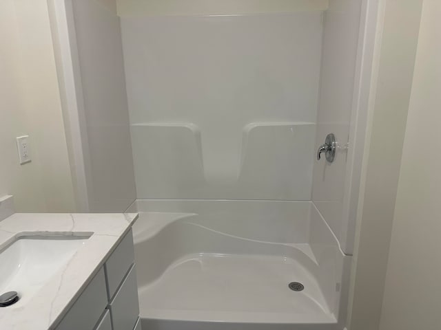 bathroom featuring a shower and vanity