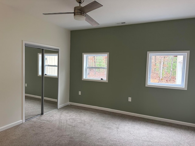 unfurnished bedroom featuring a closet, carpet flooring, and ceiling fan