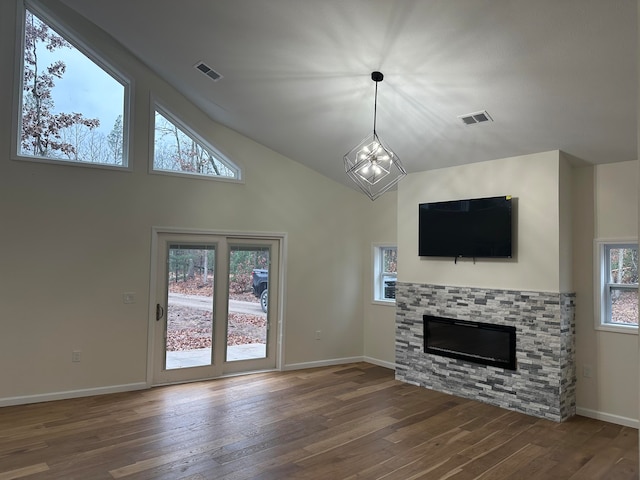 unfurnished living room featuring high vaulted ceiling, an inviting chandelier, and dark hardwood / wood-style floors