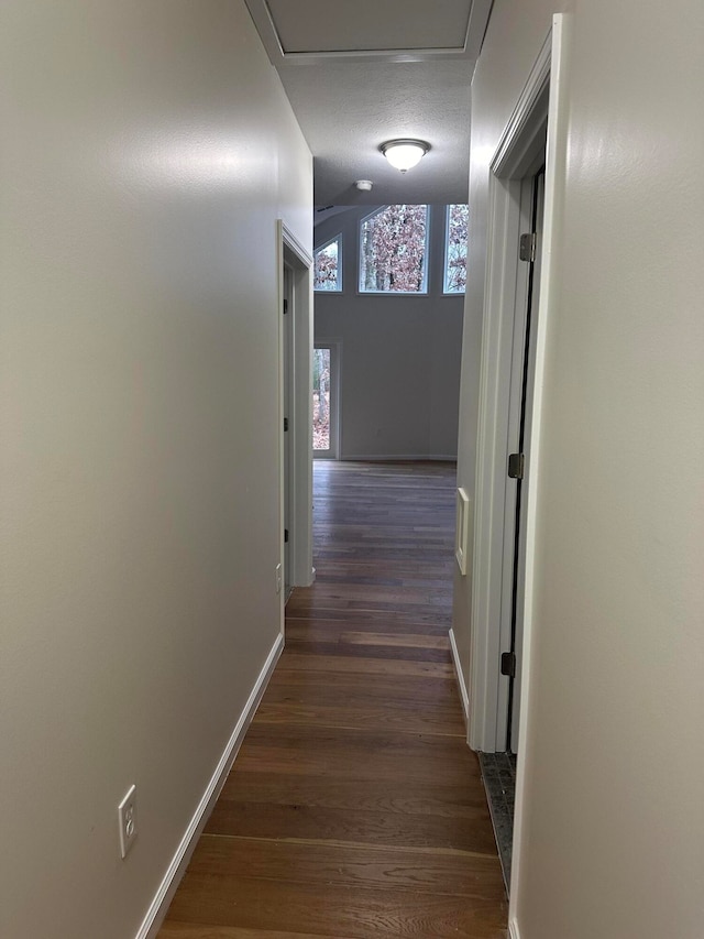 hall with dark wood-type flooring and a textured ceiling