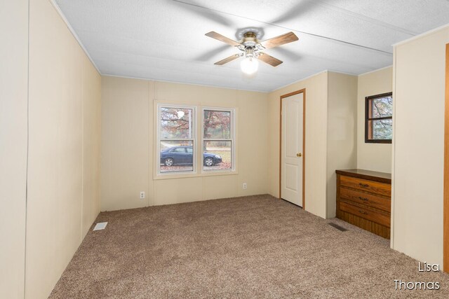 unfurnished bedroom with carpet, a textured ceiling, and ceiling fan