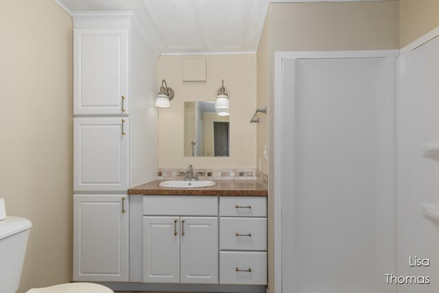 bathroom featuring ornamental molding, vanity, and toilet