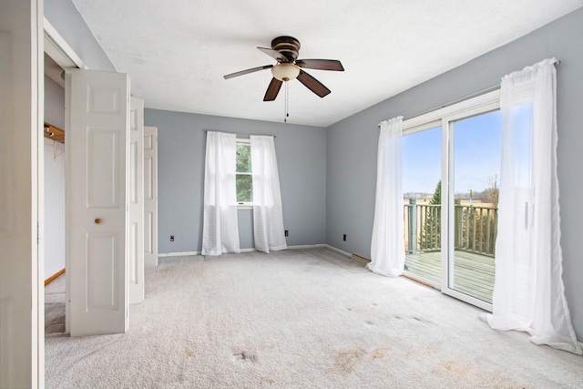 carpeted empty room featuring ceiling fan and a textured ceiling