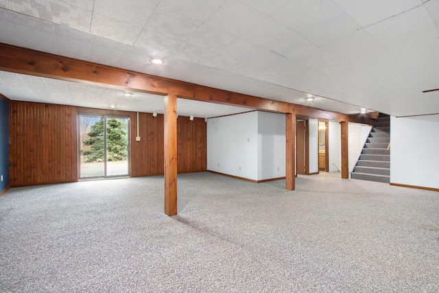 basement featuring wooden walls and light carpet