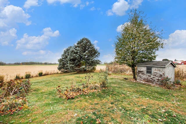 view of yard with a storage shed and a rural view