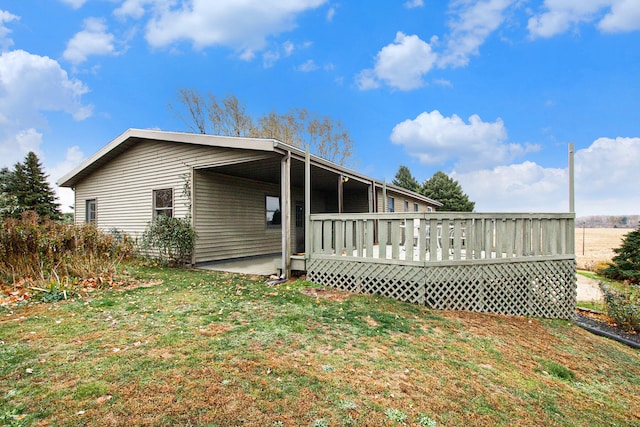 view of home's exterior featuring a wooden deck and a yard