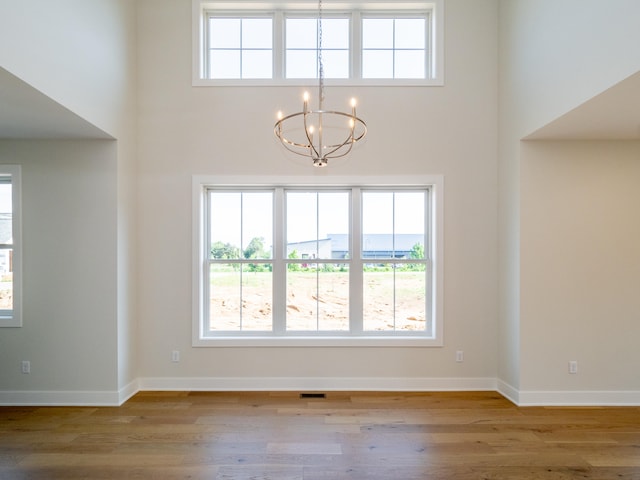 interior space with a wealth of natural light, light hardwood / wood-style floors, and an inviting chandelier