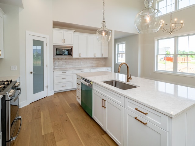 kitchen featuring light stone counters, stainless steel appliances, white cabinetry, sink, and light hardwood / wood-style floors