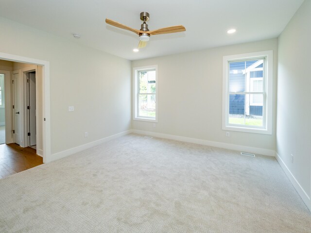 carpeted spare room with ceiling fan