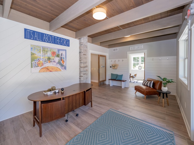 home office featuring wood walls, beam ceiling, wood ceiling, and light hardwood / wood-style flooring