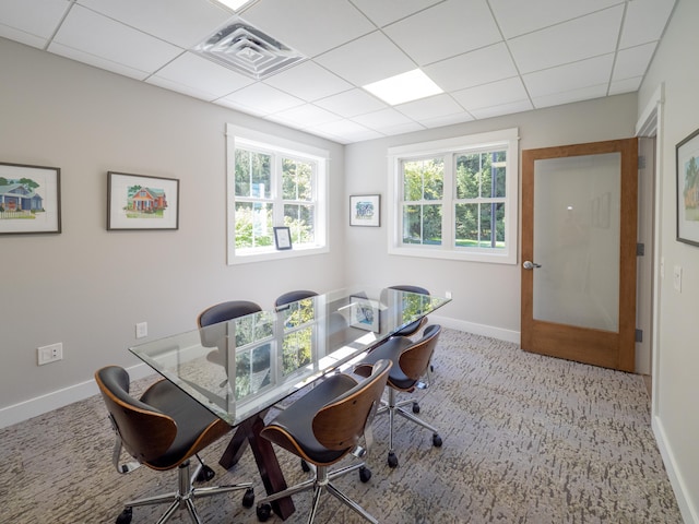 carpeted dining room with a drop ceiling