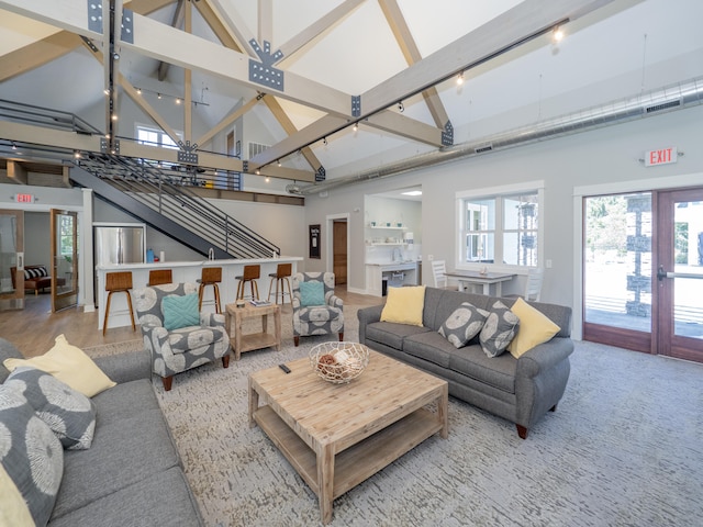 living room featuring rail lighting, beam ceiling, sink, and high vaulted ceiling