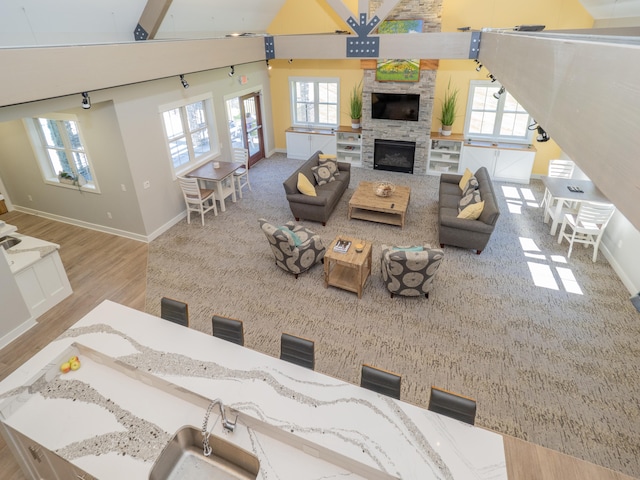 living room featuring high vaulted ceiling, a healthy amount of sunlight, and beam ceiling