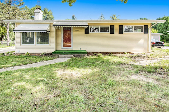 single story home featuring a front lawn