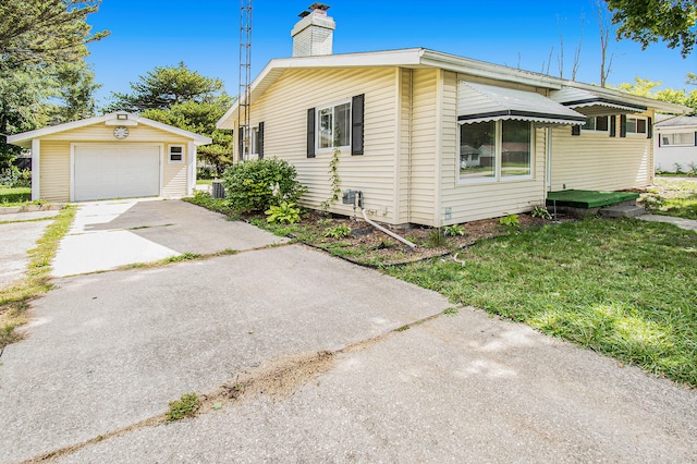 view of property exterior with a garage, a yard, and an outdoor structure