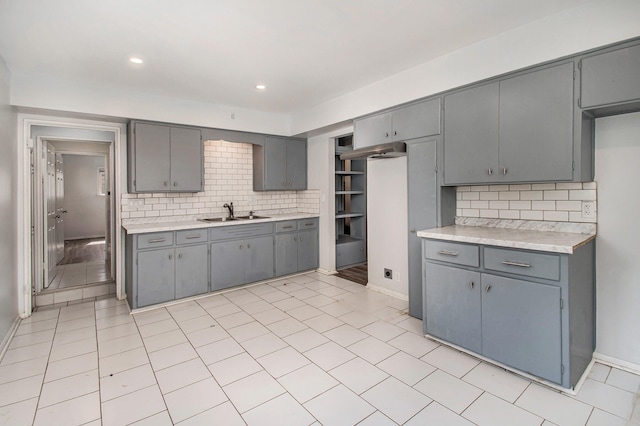 kitchen with decorative backsplash, sink, gray cabinetry, and light tile patterned floors