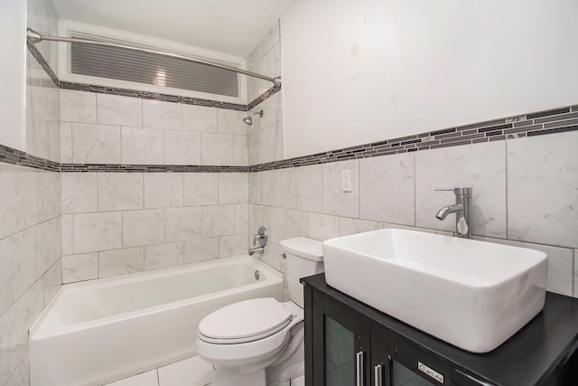 full bathroom with toilet, vanity, tiled shower / bath combo, and tile walls