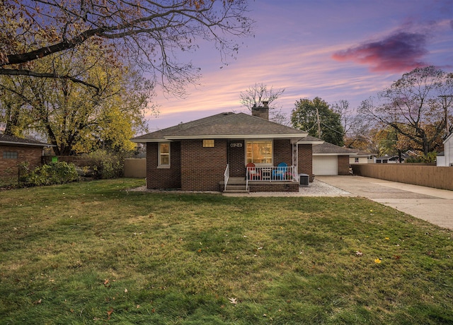 ranch-style house with a garage and a yard