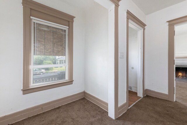 hall with dark colored carpet