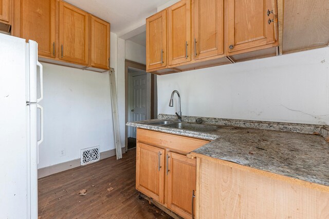 kitchen with dark wood-type flooring, sink, and white fridge