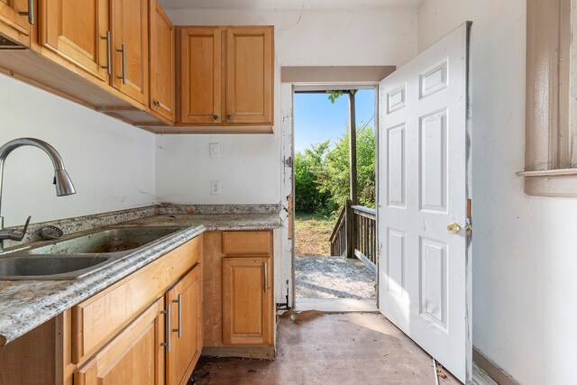 kitchen featuring sink and light stone counters