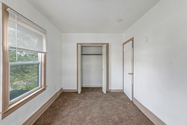 unfurnished bedroom featuring carpet and a closet