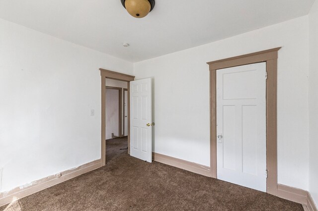 unfurnished bedroom with dark colored carpet